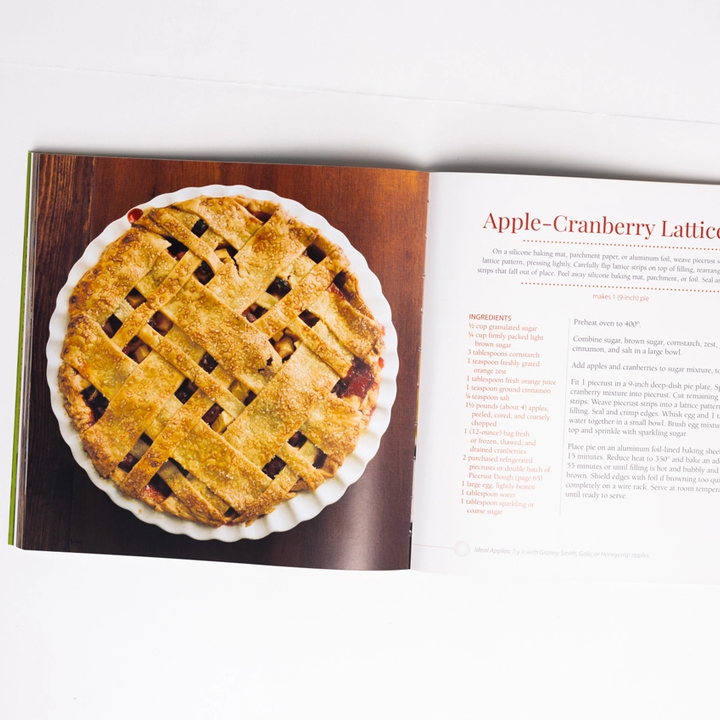 Apple Recipe Book open to a page with an apple cranberry lattice pie and recipe text.