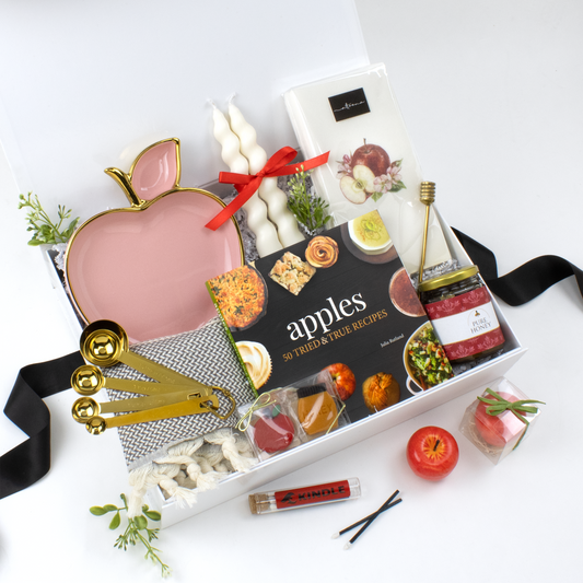 White Gift Box with Apple-themed items. Apple Cookbook, Apple-shaped Dish, Gold Measuring Spoons, Apple Candle, Tapered Candles, Honey Jar, Honey Dipper, Kitchen Towel, Long Matches, Apple Guest Towels. Holiday Gifts. Chanukah Gift. Corporate Gift.